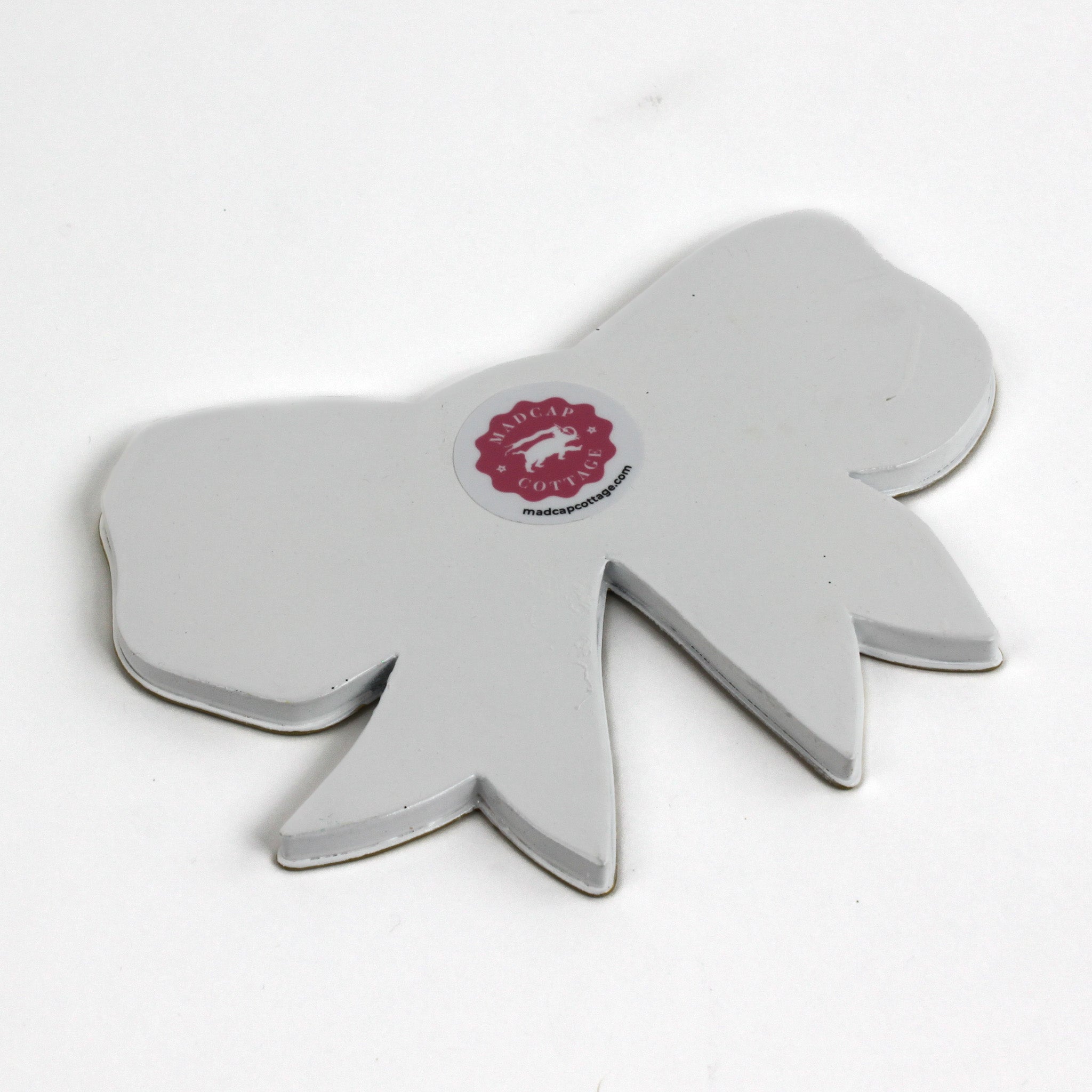 Back view of a bow-shaped tray showing the plain finish and maker label.