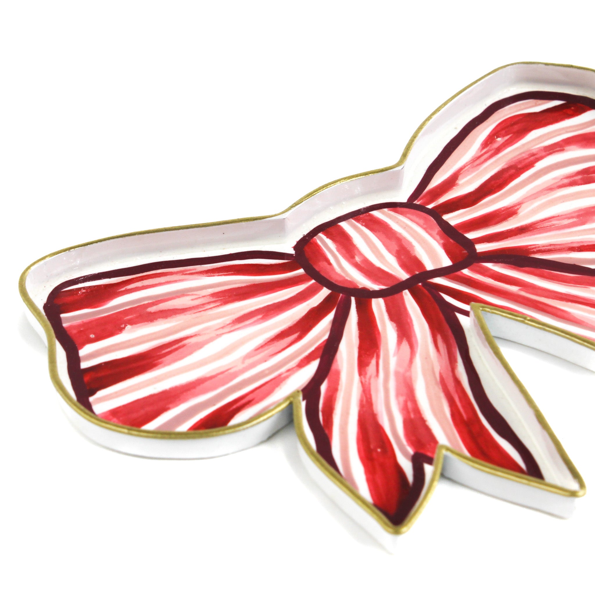 Close-up of a red and white striped bow-shaped decorative tray with gold trim.
