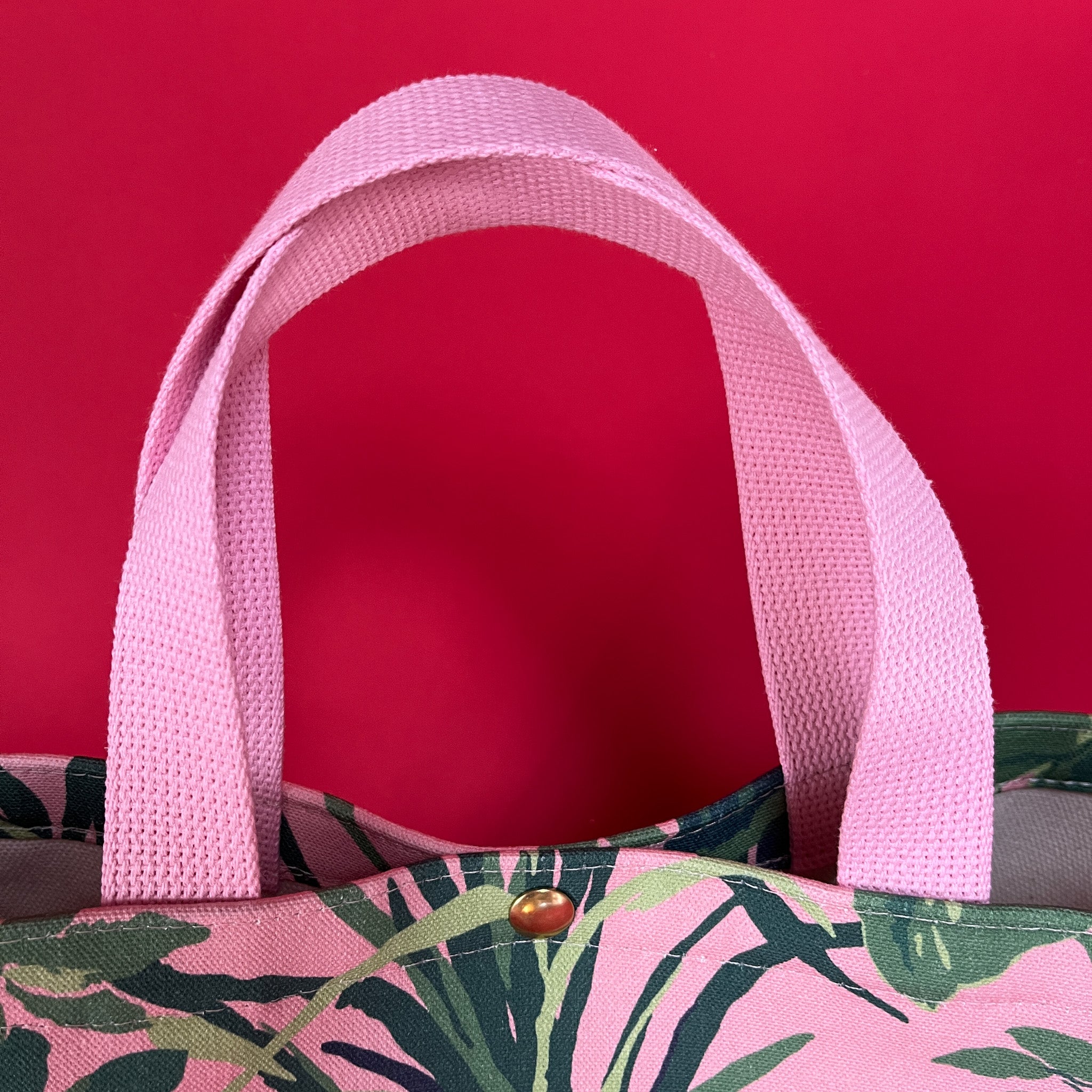 Handle detail of the small Jungle Road canvas tote in pink and green