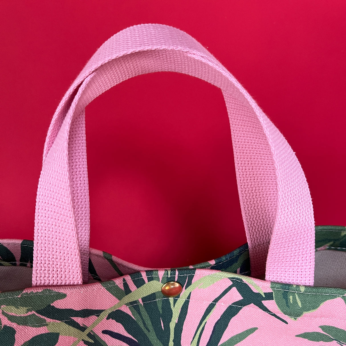 Handle detail of the small Jungle Road canvas tote in pink and green