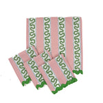Pink and green striped napkin and table runner set with scalloped green edges displayed flat.