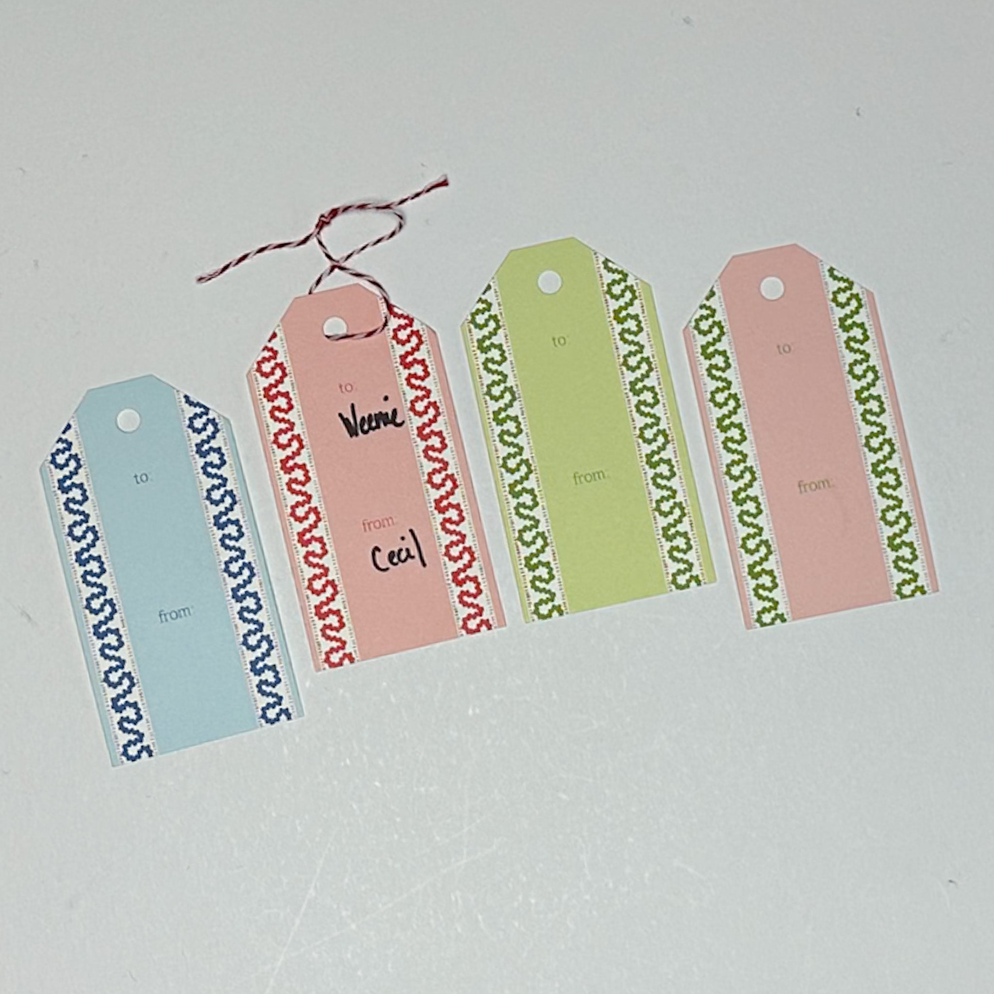 A set of colorful gift tags with decorative borders. The tags are laid out on a white surface.