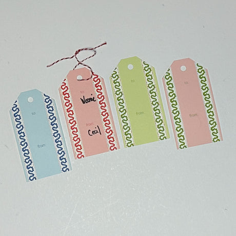 A set of colorful gift tags with decorative borders. The tags are laid out on a white surface.