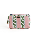 A Bahama pink Harbor Trail Medium Cosmetics Bag with a toiletry and makeup items inside, set against a white background.