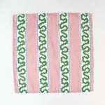 Green and light green geometric arrow print cloth napkin folded open to show pattern, modern cotton table linen.