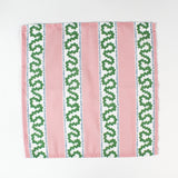 Green and light green geometric arrow print cloth napkin folded open to show pattern, modern cotton table linen.