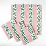 Set of handmade cloth napkins with pink stripes and green wavy trim pattern, displayed with matching dinner napkins for table decor.