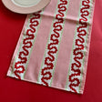 Detailed view of the Harbor Trail Pink and Red cloth table runner on a red background