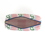 Interior view of Harbor Trail toiletry bag in Bahama pink with a green ribbon and blue dash motif.