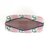 Interior view of Harbor Trail toiletry bag in Bahama pink with a green ribbon and blue dash motif.