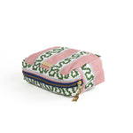 A Bahama pink Harbor Trail Medium Cosmetics Bag with a toiletry and makeup items inside, set against a white background.