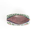 Interior view of amedium Harbor Trail toiletry bag in Bahama pink with a green ribbon and blue dash motif.