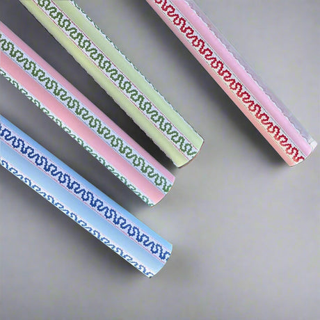 Four rolls of wrapping paper in fancy stripe patterns of assorted colors.