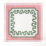a square acrylic tray with a pink and green base featuring a green squiggle motif around the border.
