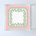 a square acrylic tray with a pink and green base featuring a green squiggle motif around the border.