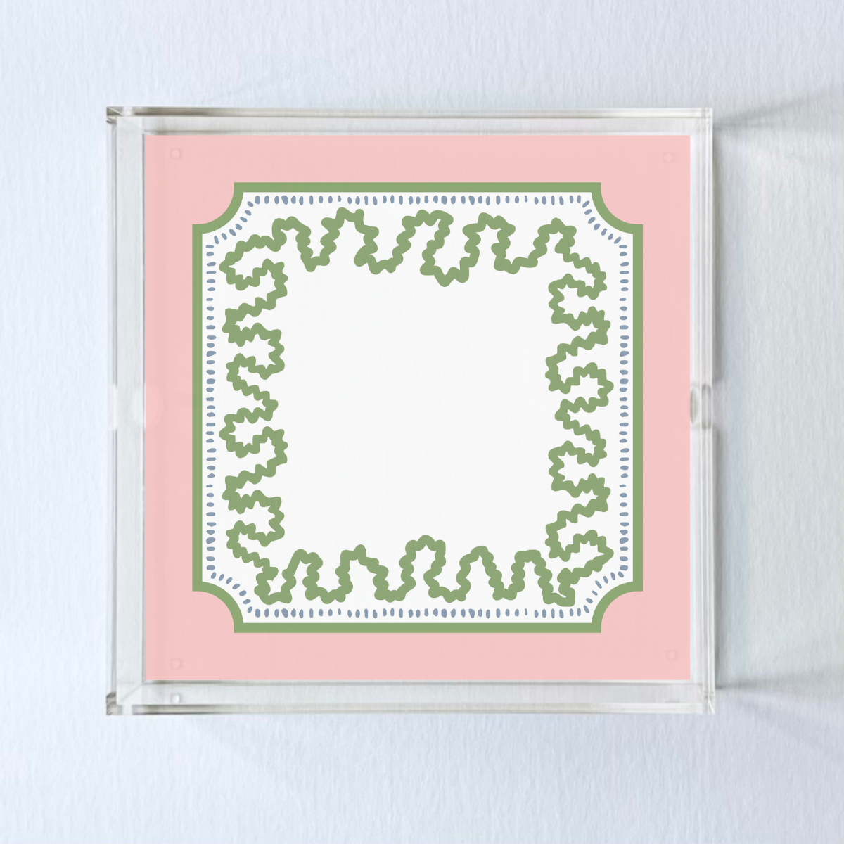 a square acrylic tray with a pink and green base featuring a green squiggle motif around the border.