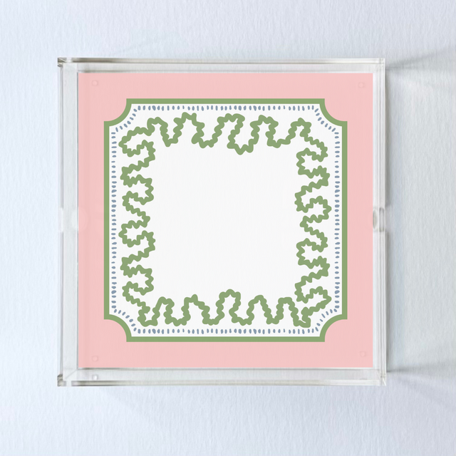 a square acrylic tray with a pink and green base featuring a green squiggle motif around the border.