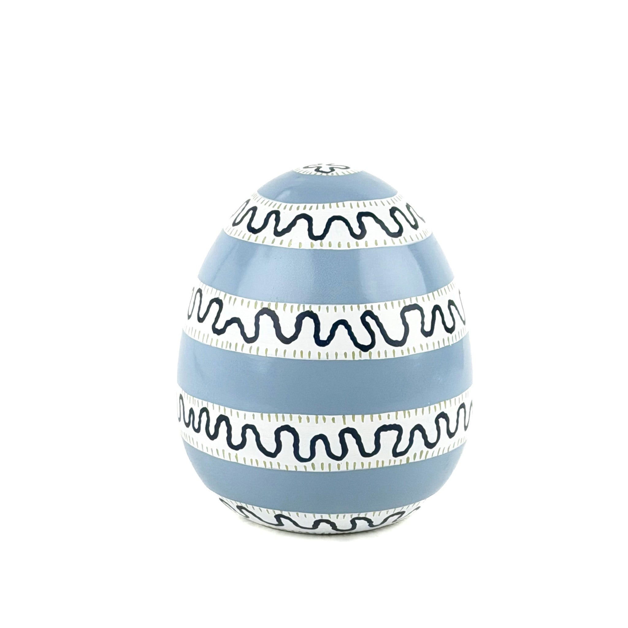 a white, black and blue striped decorative Easter egg with on white background.