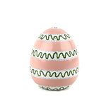 A white, green and pink striped decorative Easter egg with on white background.