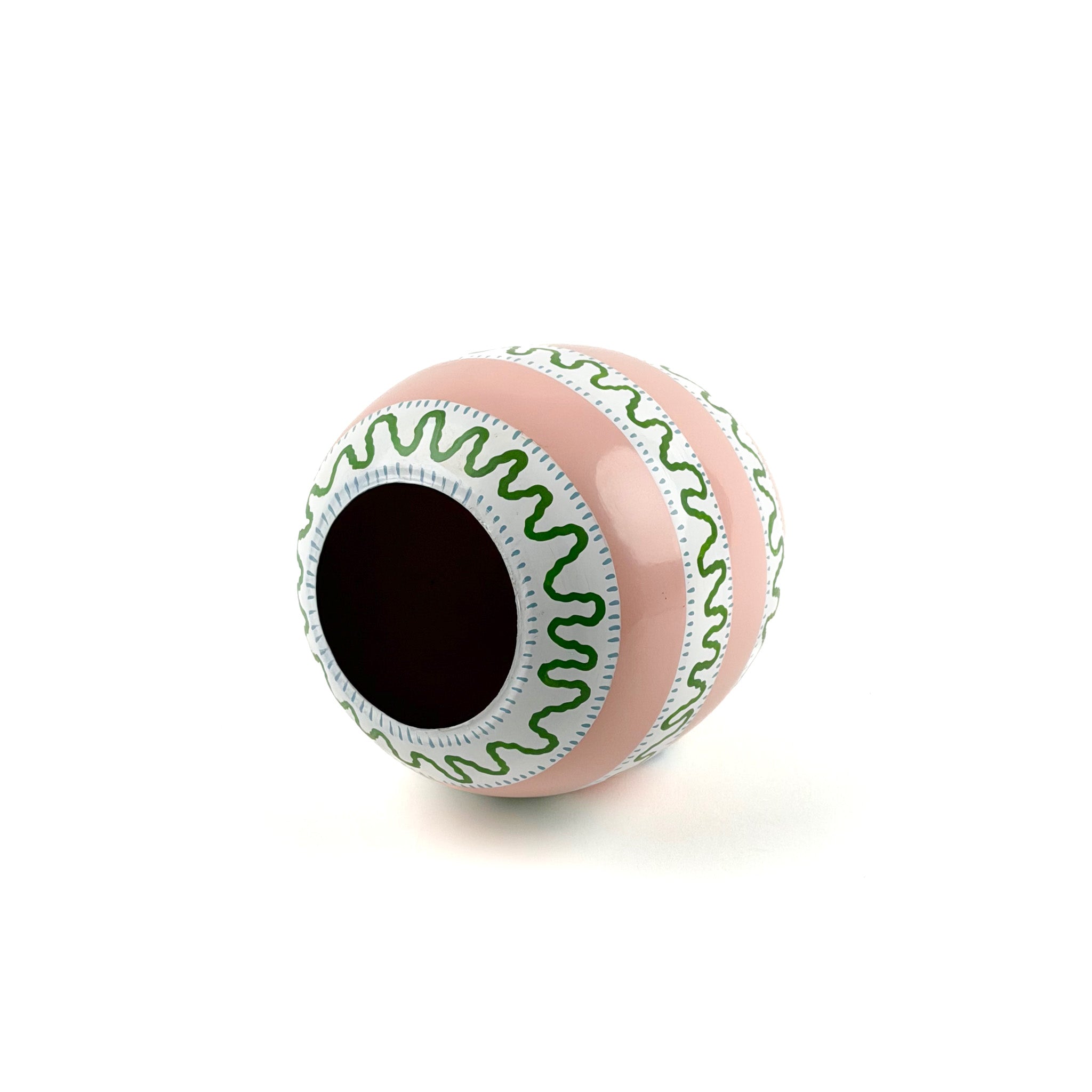 bottom view of a white, green and pink striped decorative Easter egg with on white background.