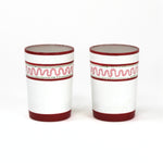 two red painted glasses with a squiggly motif at the top called "Harbor Trail" by madcap cottage