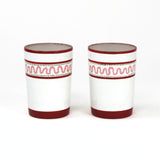 two red painted glasses with a squiggly motif at the top called "Harbor Trail" by madcap cottage