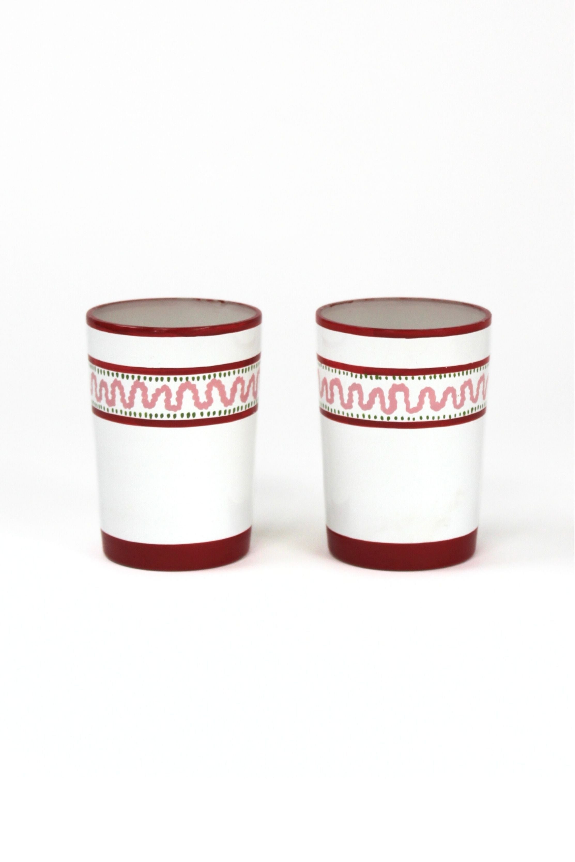 two red painted glasses with a squiggly motif at the top called "Harbor Trail" by madcap cottage