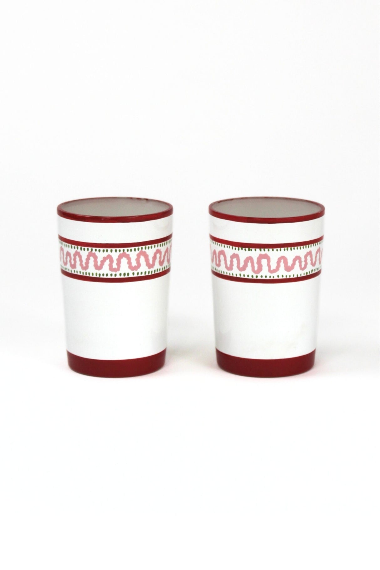 two red painted glasses with a squiggly motif at the top called "Harbor Trail" by madcap cottage