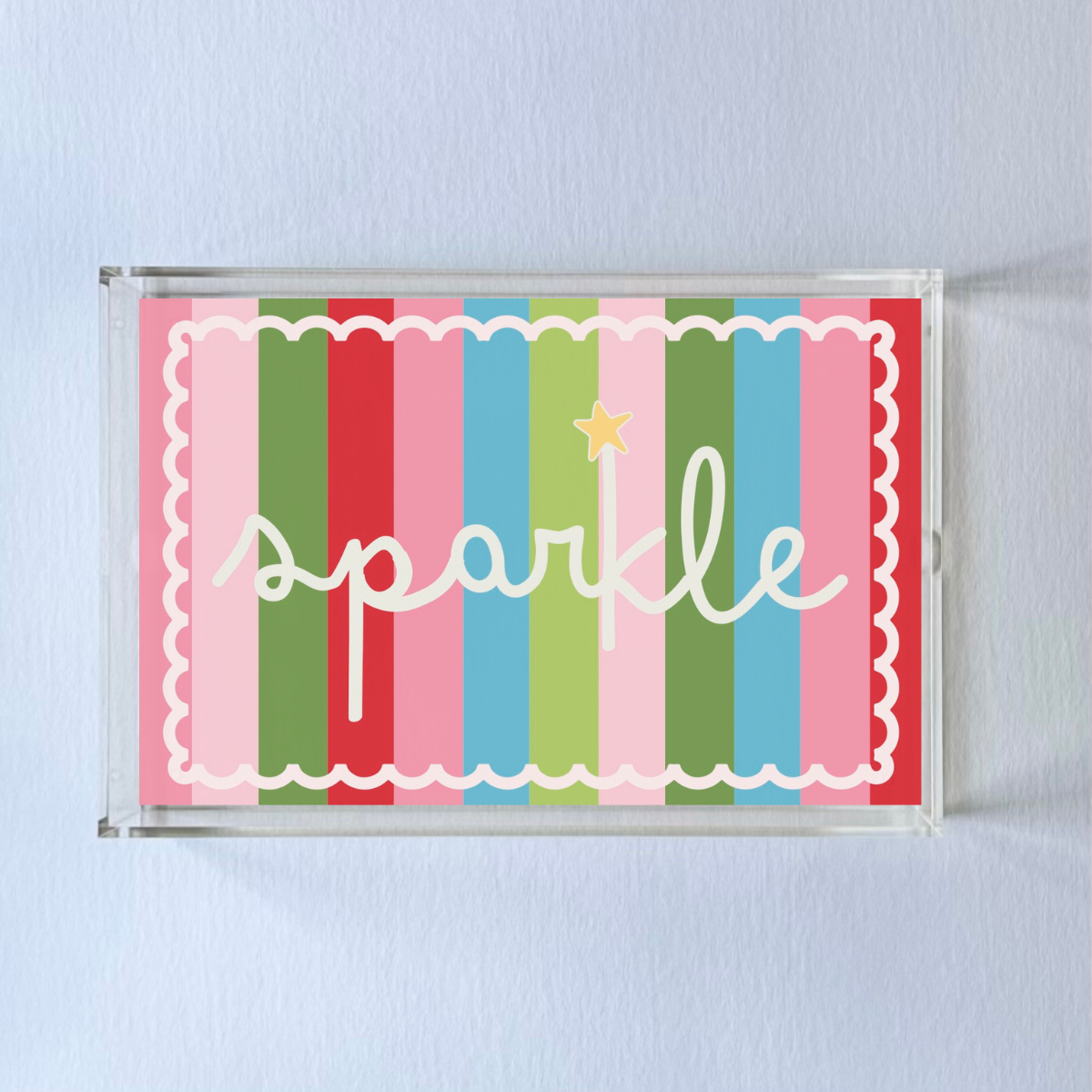 A rectangular acrylic tray with colorful striped pattern and the word 'sparkle' displayed prominently in the center.