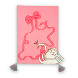 pink christmas tea towel featuring a large swan and pink ribbon design and blue and pink tassels with a madcap cottage card on the side bottom