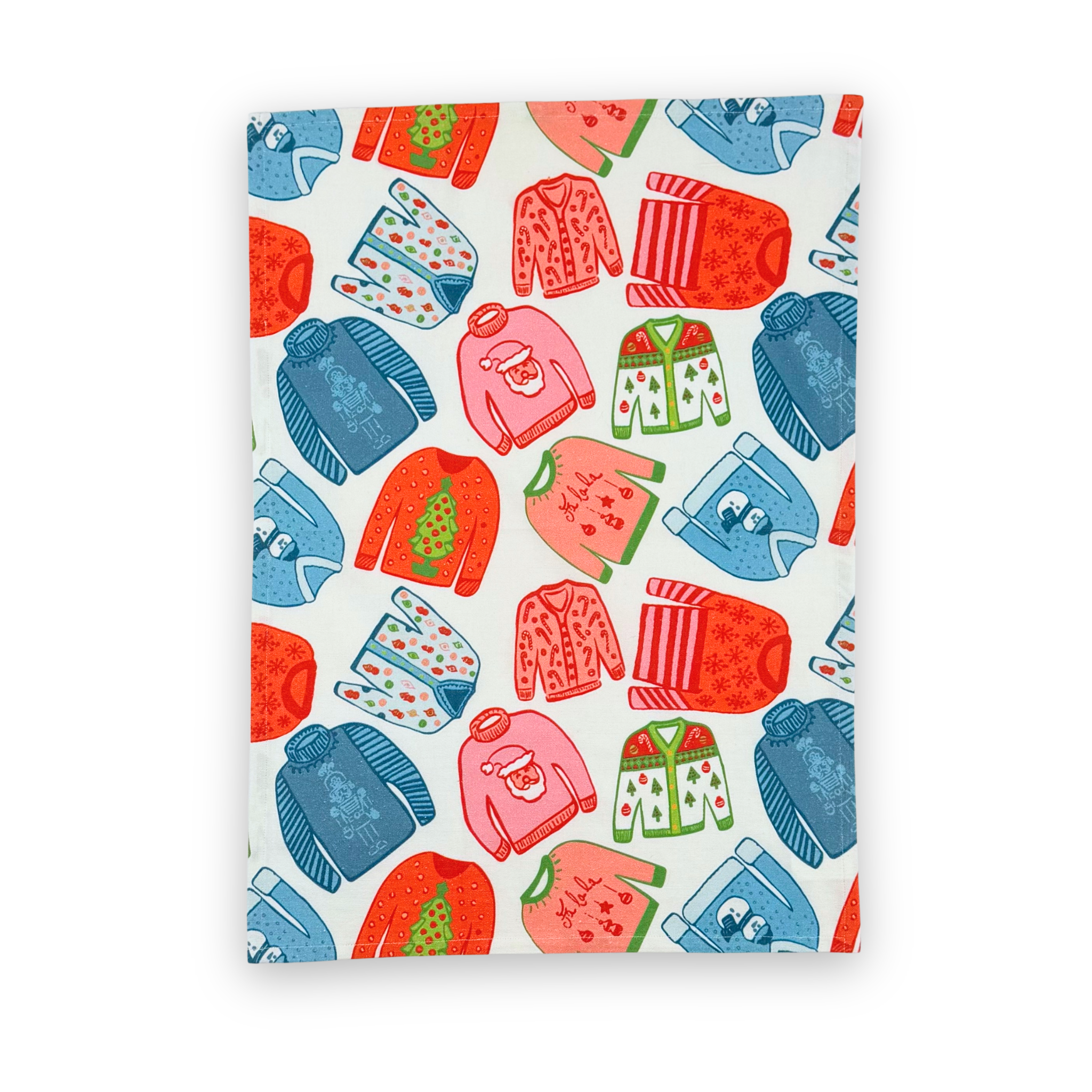 a christmas tea towel featuring a repeating holiday sweater design in red, pink and blue
