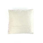 plain white velvet reverse side of a white and pink striped christmas pillow with holly design and red bow on a white background.