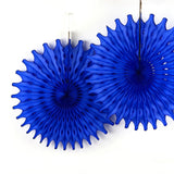 A two blue honeycomb paper fan decorations with starburst shapes hanging against a white background.