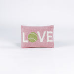 A pink pillow with the word "LOVE," where the "O" is a green tennis ball.