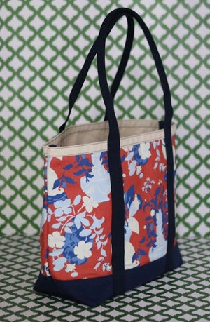 Front 3/4 view of Imperial Palace red canvas tote on a green and white background