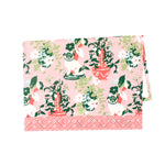 a pink and green chinoiserie pug tea towel with repeating dogs and flower filled vase motifs against a white background. 