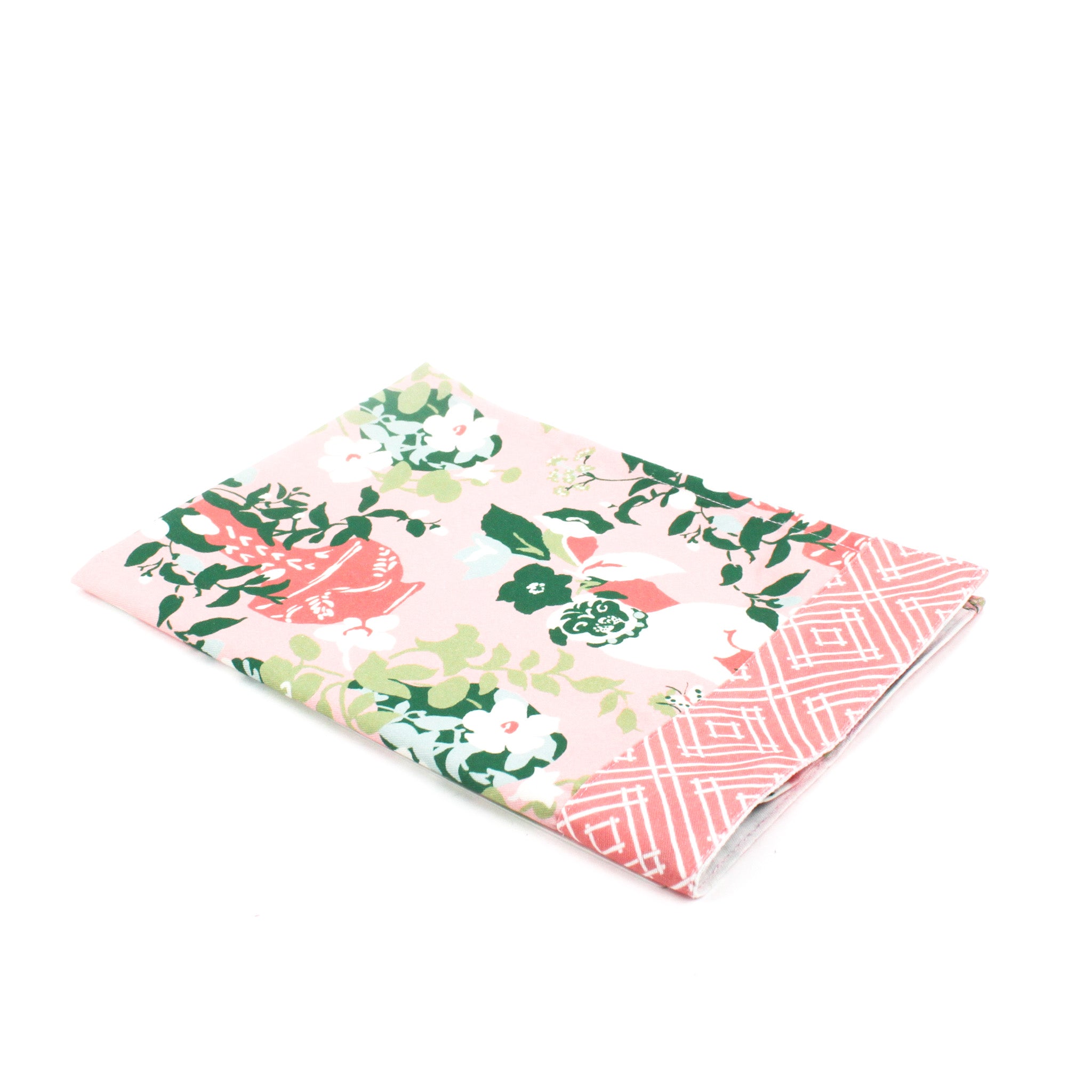 a pink and green chinoiserie pug tea towel with repeating dogs and flower filled vase motifs against a white background. 