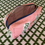 Interior view of Harbor Trail toiletry bag in Bahama pink with a green ribbon and blue dash motif.