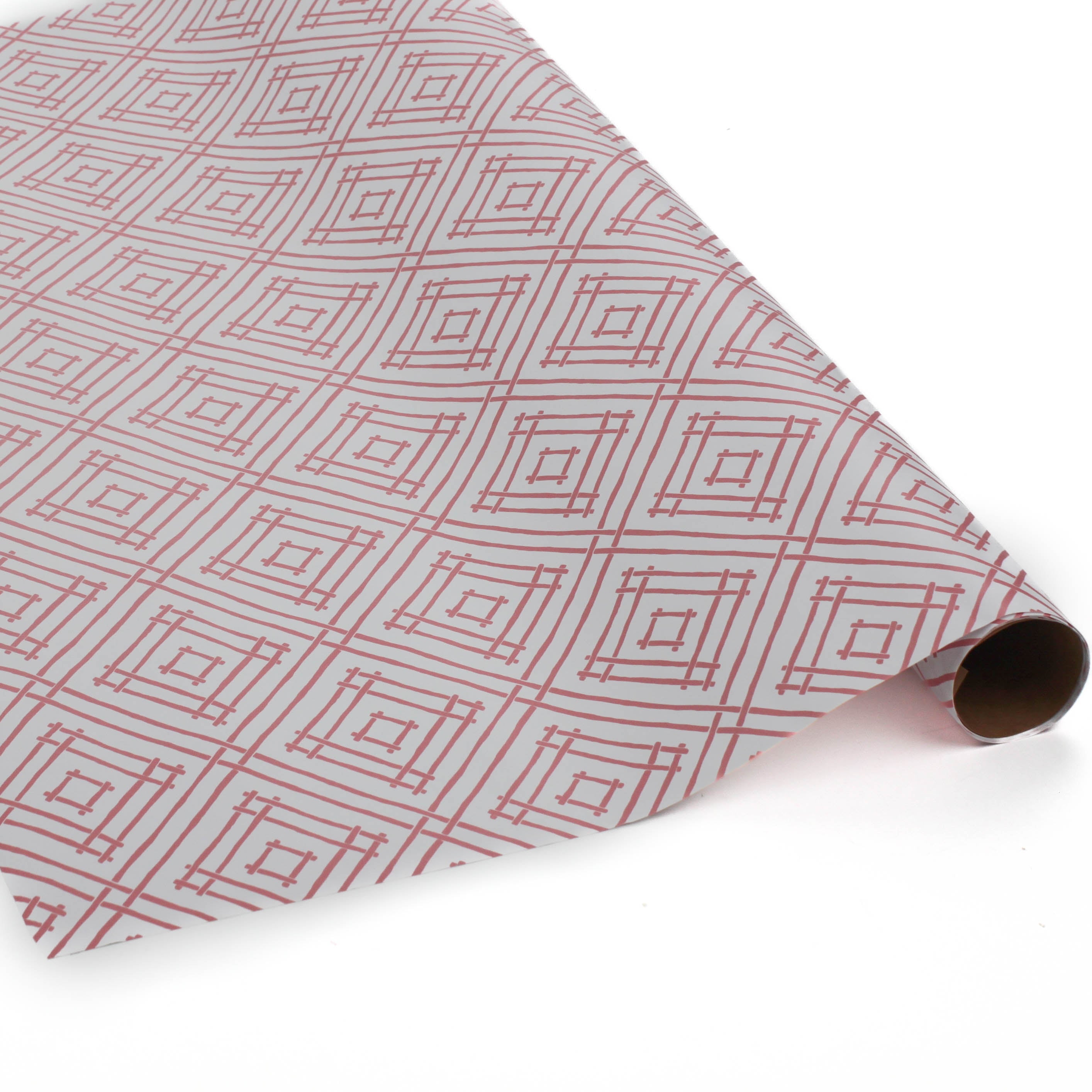 a roll of wrapping paper with a geometric lattice pattern in pink