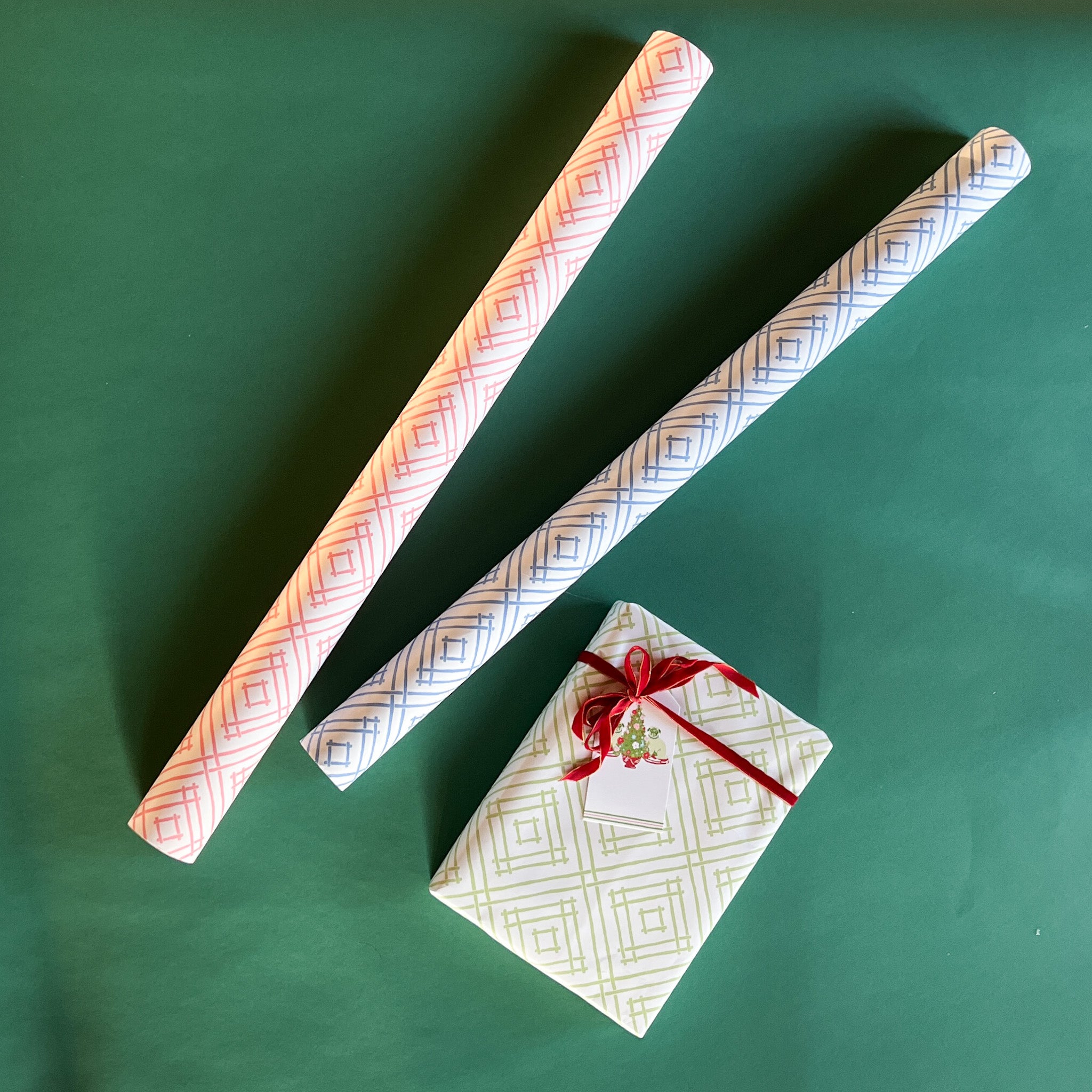 Rolls of gift wrapping paper with a geometric lattice pattern in green, blue, and pink colors.