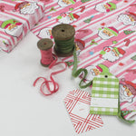 Colorful Christmas wrapping paper featuring santa, candy cane and christmas tree motifs. 