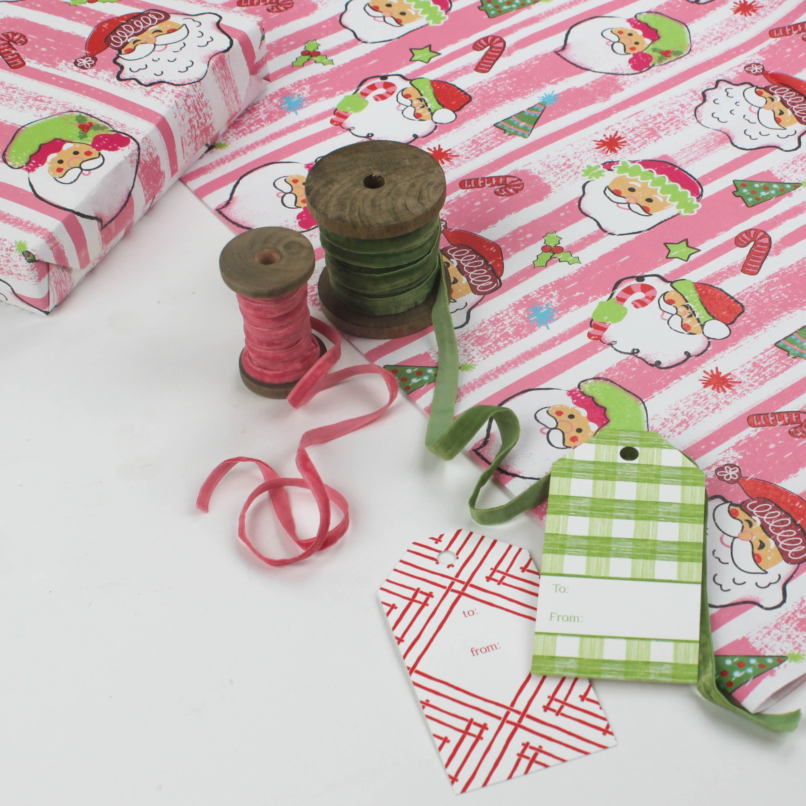 Colorful Christmas wrapping paper featuring santa, candy cane and christmas tree motifs. 