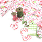 Colorful Christmas wrapping paper featuring santa, candy cane and christmas tree motifs. 