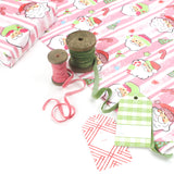 Colorful Christmas wrapping paper featuring santa, candy cane and christmas tree motifs. 
