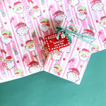 Colorful Christmas wrapping paper featuring santa, candy cane and christmas tree motifs. 