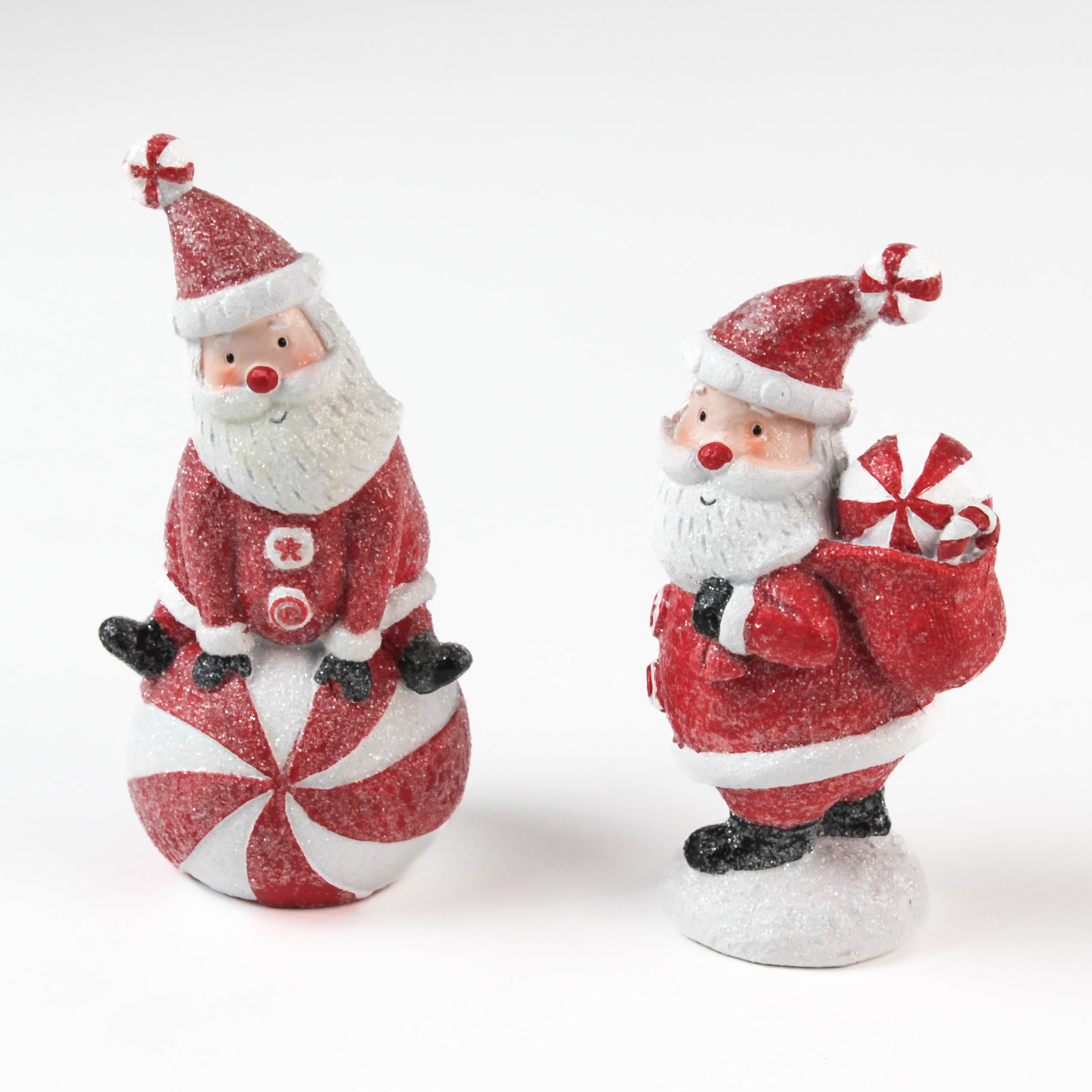 Two Santa Claus table decorations on a white background