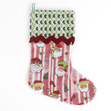 Pink Christmas stocking with Santa Claus design and a green cuff on a white background