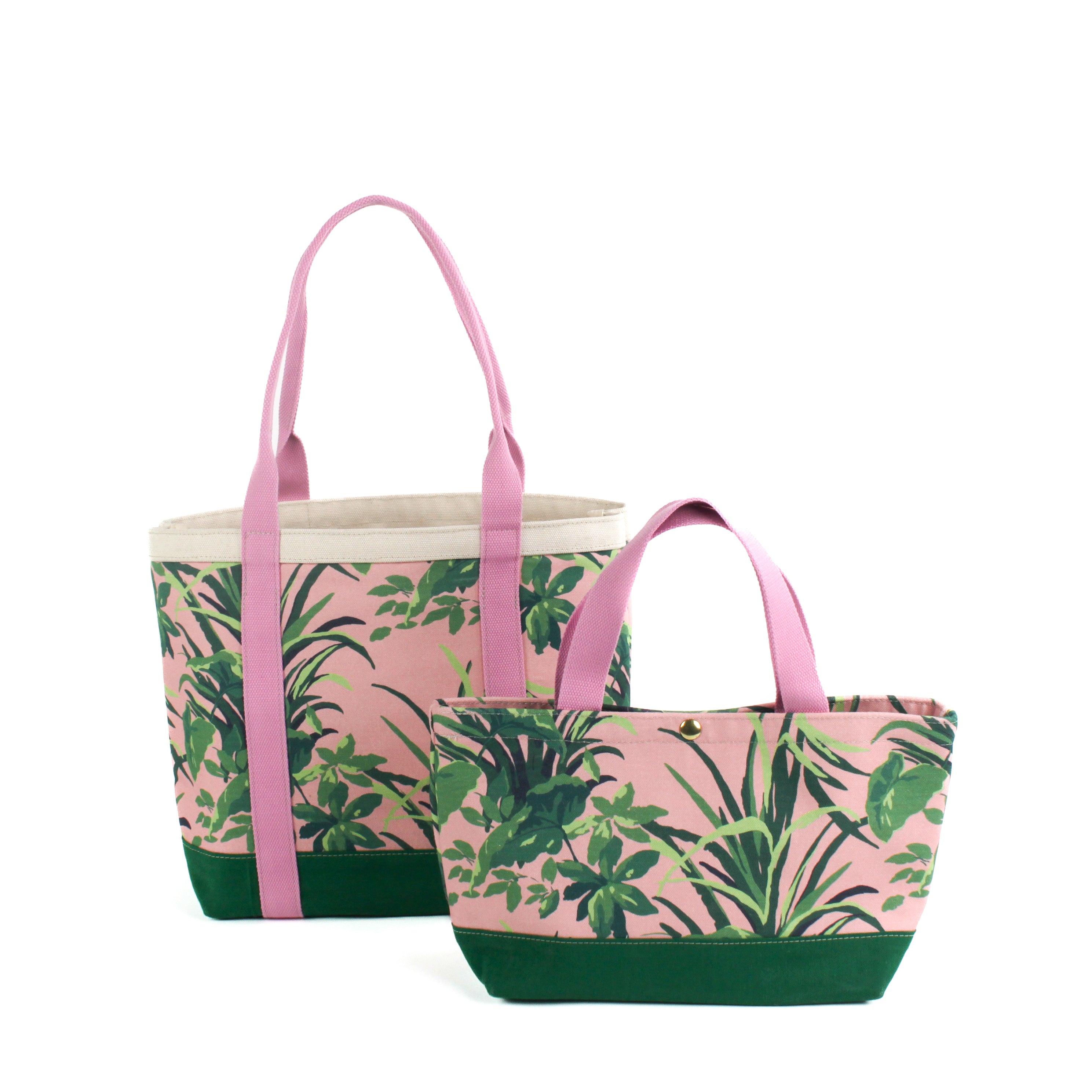Two Jungle Road canvas tote bags with a pink and green leaf pattern, displayed against a white background.