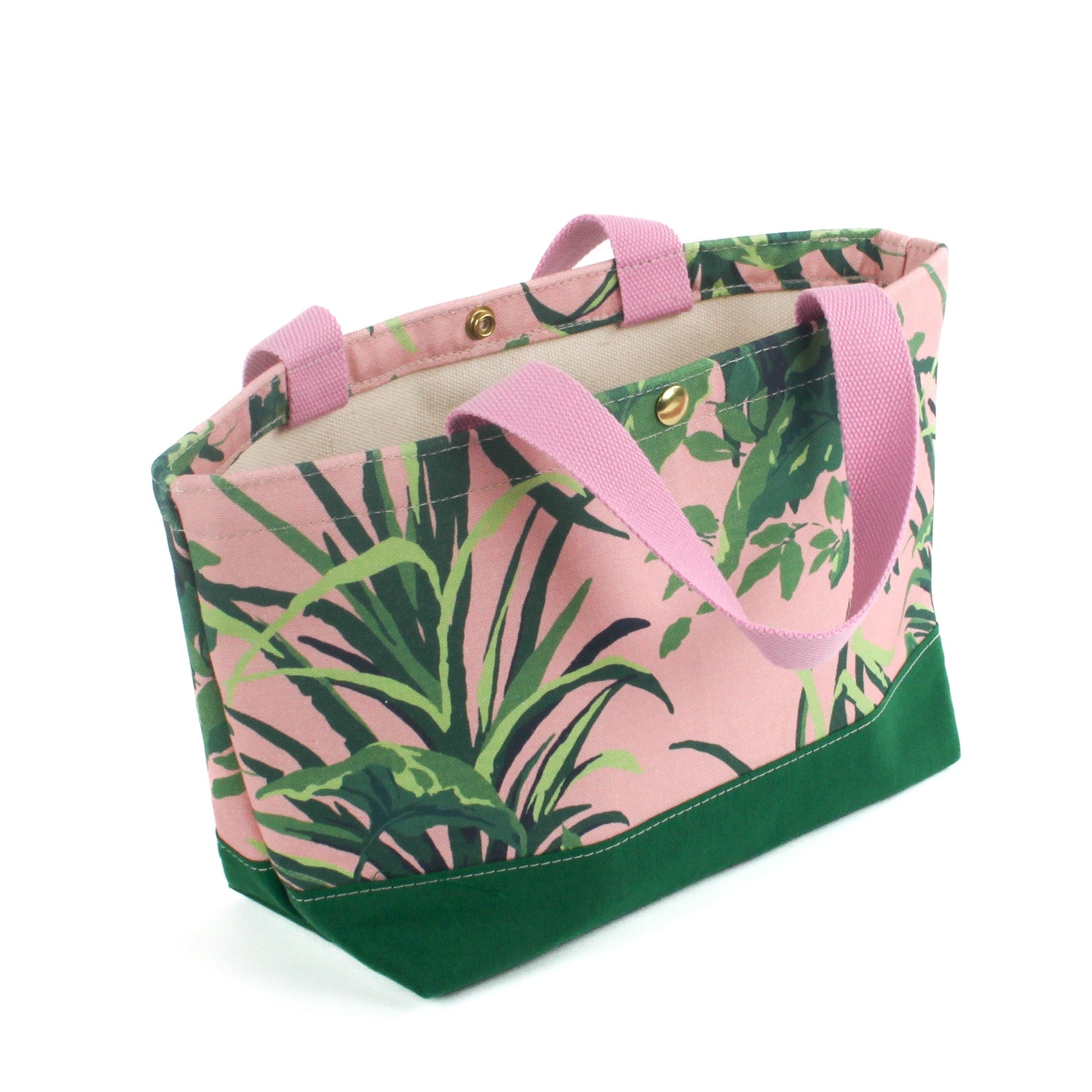 a small Jungle Road canvas tote bags with a pink and green leaf pattern, displayed against a white background.