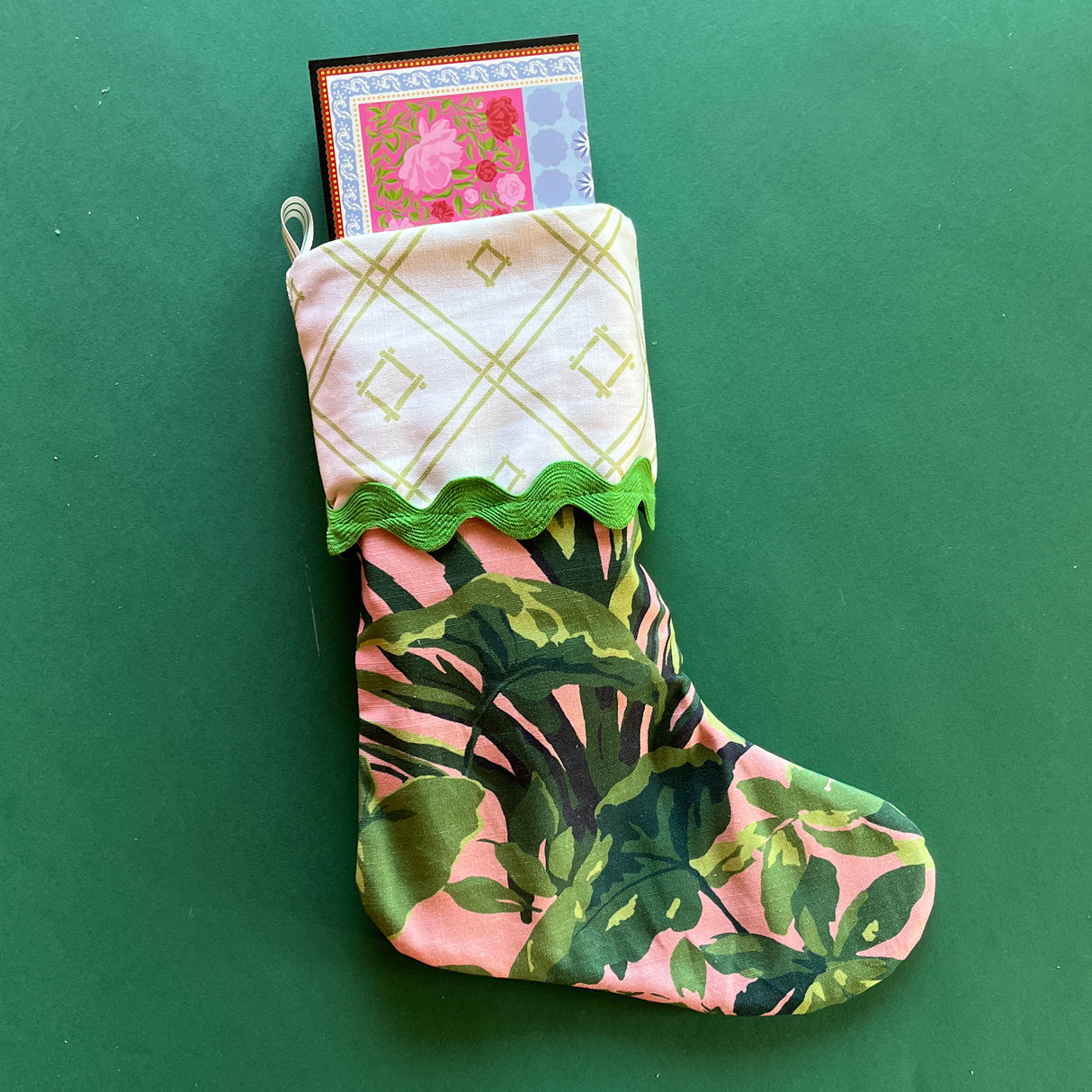 A palm leaf print pink and green Christmas stocking.